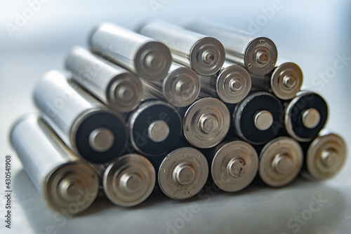 Batteries arranged on top of each other, on a light surface. Batteries, energy and respect for the environment. Alkaline or rechargeable batteries.