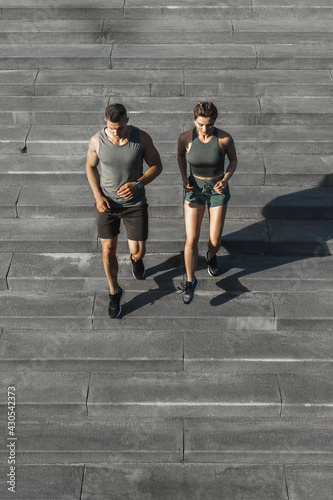 Sportive couple during workout stair running outdoors