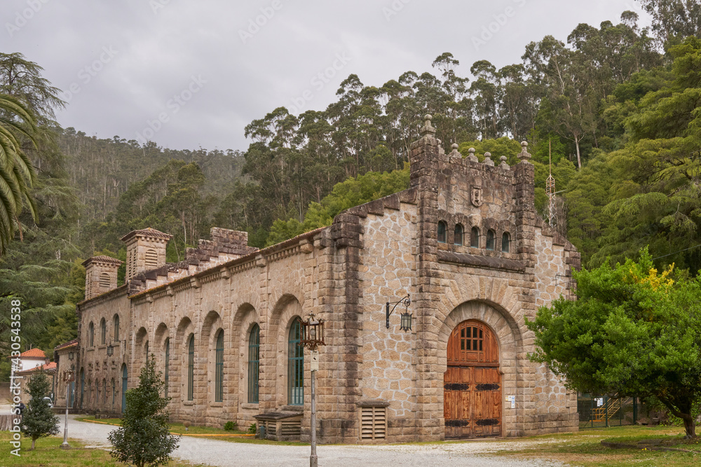 large stone building among nature. it is an hydroelectric plant at the tambre river in noia, galicia