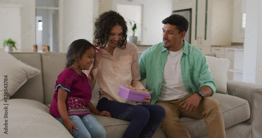 Happy hispanic woman getting presents from huband and daughter Happy hispanic woman getting presents from huband and daughter