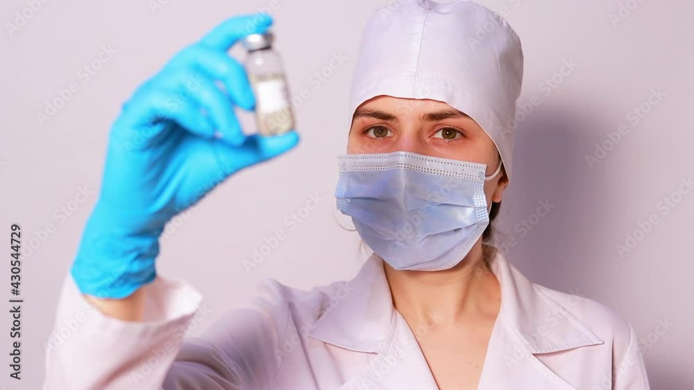 A doctor or lab technician holds a measles vaccine. Measles epidemic, measles encephalitis. The concept of vaccination in health care A doctor or lab technician holds a measles vaccine. Measles epidemic, measles encephalitis. The concept of vaccination in health care