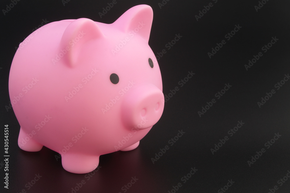Piggy bank on black table, space for text.