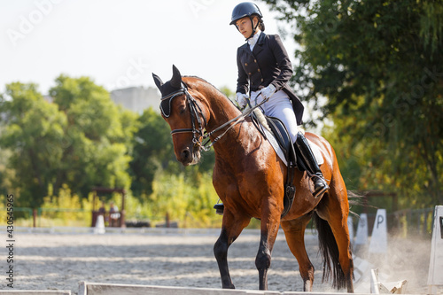 Young girl riding horse at dressage advanced test