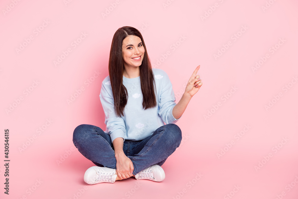 Full size photo of young lovely smiling good mood girl sit floor advertising product isolated on pink color background Full size photo of young lovely smiling good mood girl sit floor advertising product isolated on pink color background