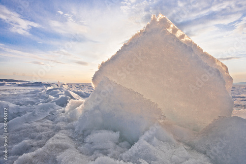 Obraz na plátně Yellow-orange light of the sun shines through an ice floe, a hummock on Baikal i