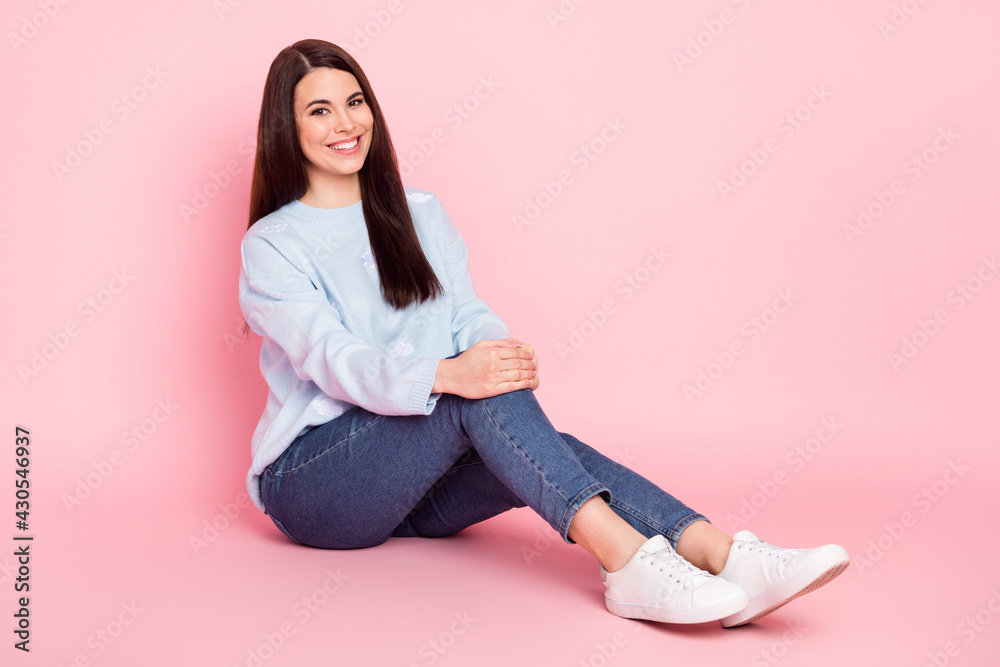 Full size photo of young happy cheerful smiling lovely girl sit floor enjoying free time isolated on pink color background