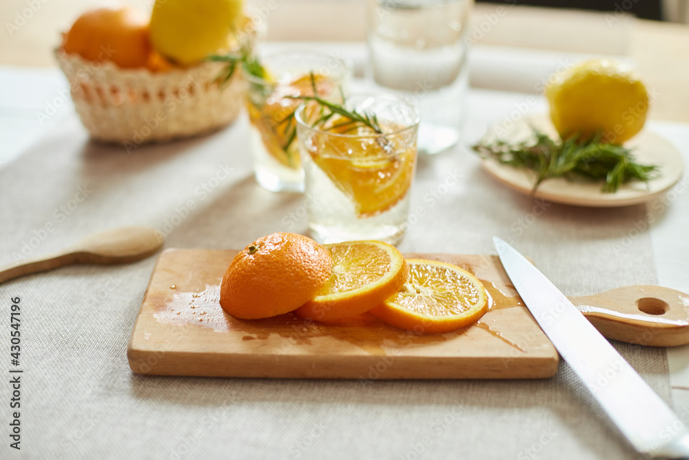 Citrus and rosemary fresh lemonade in glass on a white table at home Citrus and rosemary fresh lemonade in glass on a white table at home