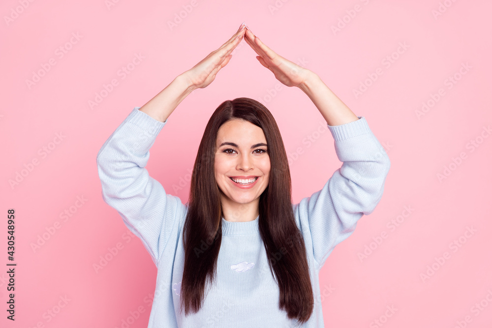 Naklejka premium Photo of pretty sweet young lady dressed blue sweater smiling showing arms roof isolated pink color background