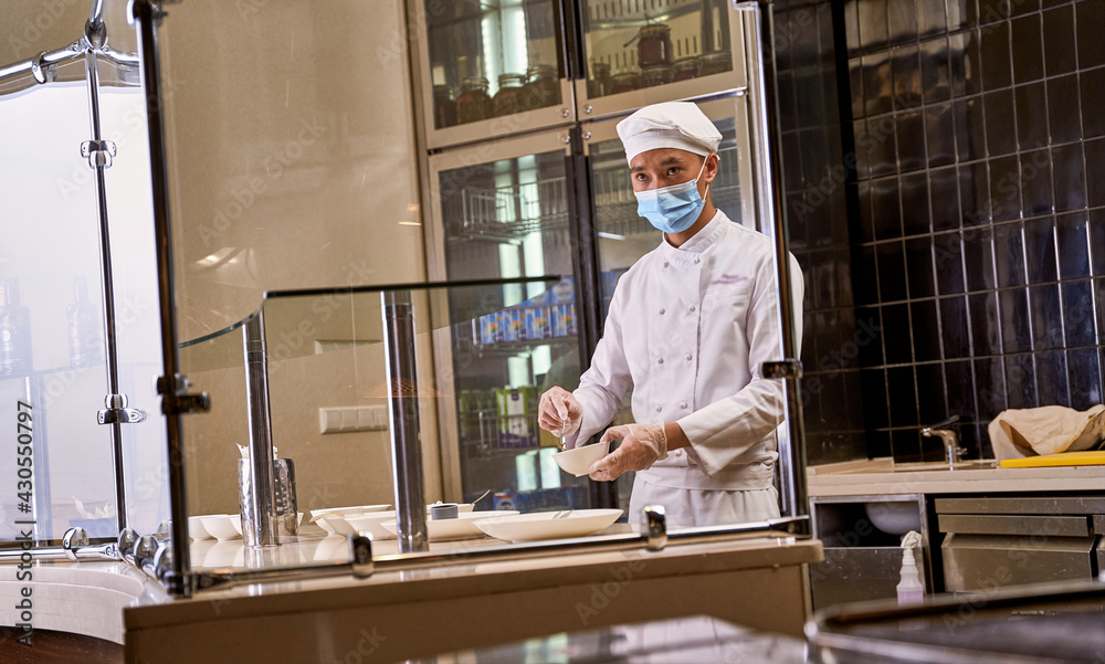 Asian chef getting distracted while mixing a dish Asian chef getting distracted while mixing a dish