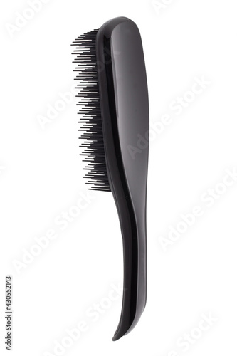 Closeup of a stylish new black hair brush isolated on white background. Concept of body and beauty care. Macro.