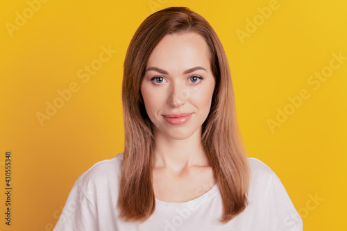 Close-up of a woman smiling good mood look camera on yellow background © Tetiana