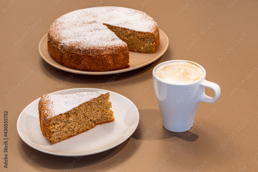 A cup of fresh cappuccino and a piece of cake made from almonds and dry bread (Antica torta alle mandorle e pane) A cup of fresh cappuccino and a piece of cake made from almonds and dry bread (Antica torta alle mandorle e pane)