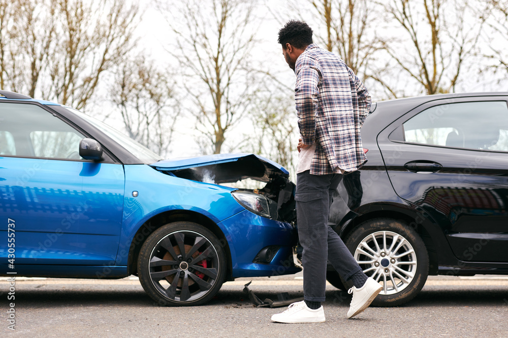 Young Male Driver Getting Out Of Car And Inspecting Damage After Road Traffic Accident Young Male Driver Getting Out Of Car And Inspecting Damage After Road Traffic Accident