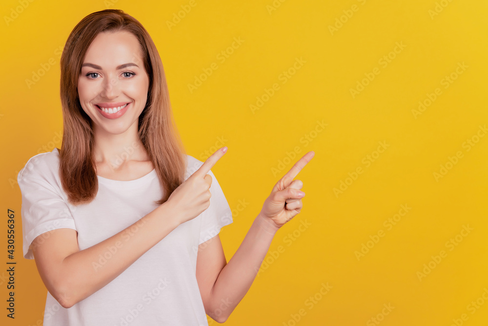 Young elegant woman direct finger empty space on yellow background Young elegant woman direct finger empty space on yellow background