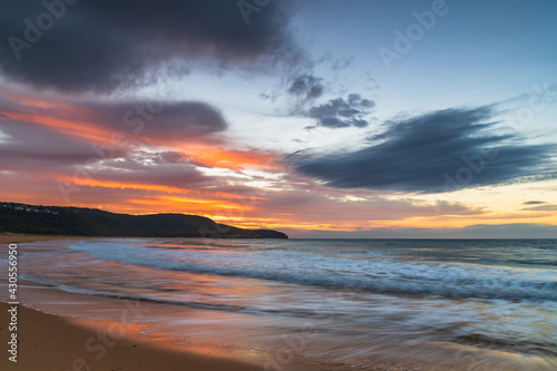 Sunrise at the seaside with pastel coloured clouds