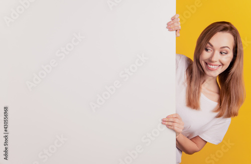 Close-up portrait of positive adviser girl look hold white billboard