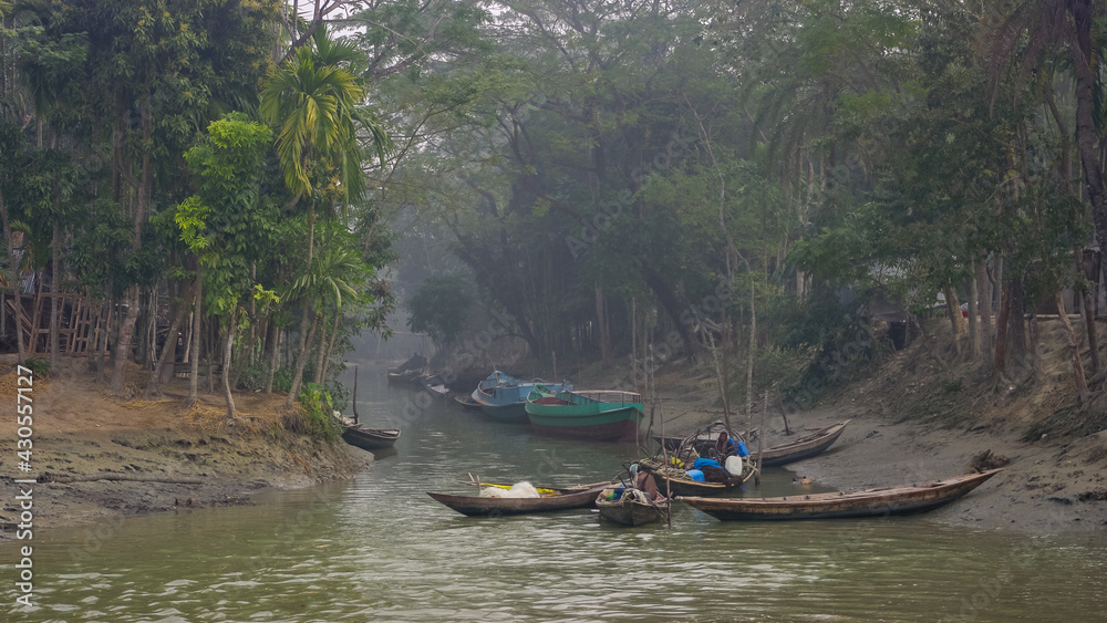Landscape view in the morning haze of fishing boats on the water in green environment, Mehendiganj, Barisal, Bangladesh
