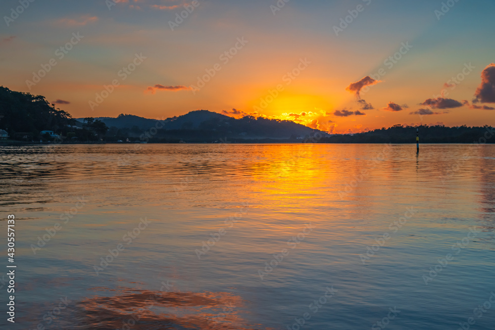 Sunrise waterscape with scattered clouds