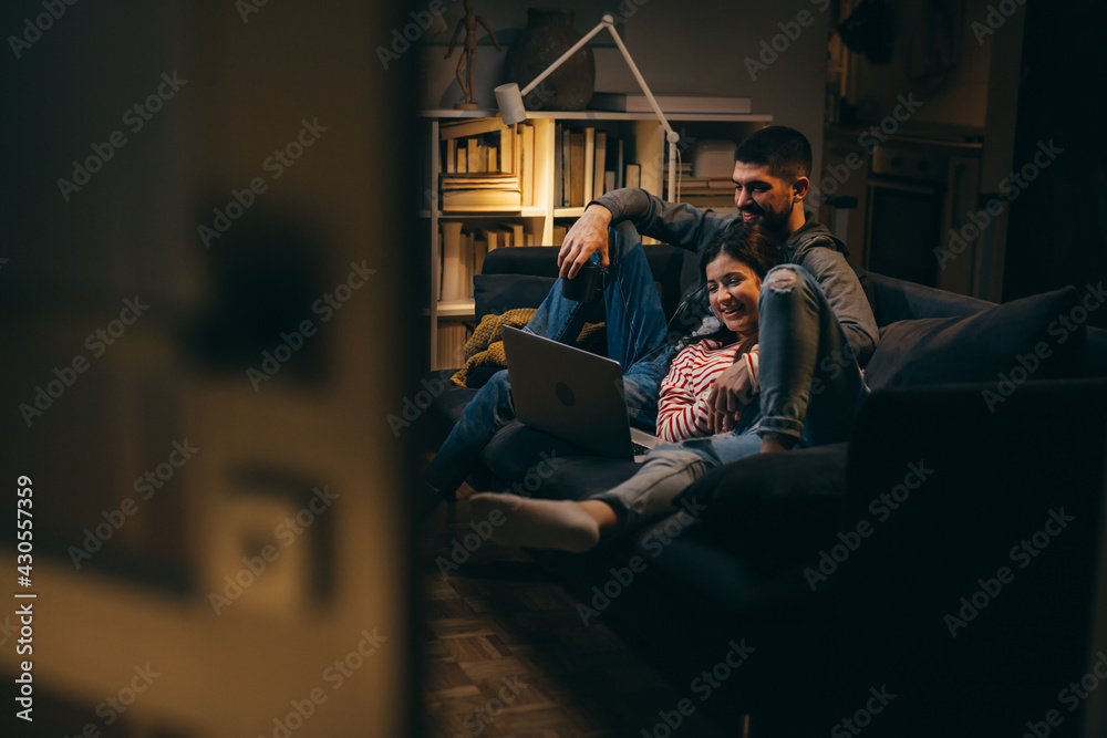 couple relaxing at home using laptop computer