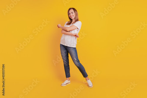 Full length body size of positive glad girl dance on yellow wall