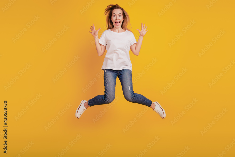 Photo of charming nice positive girl jumping open mouth on yellow background