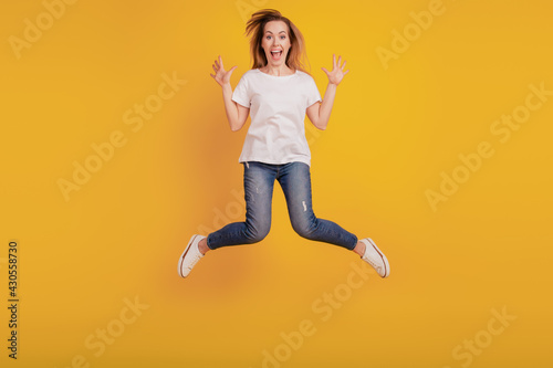 Photo of charming nice positive girl jumping open mouth on yellow background