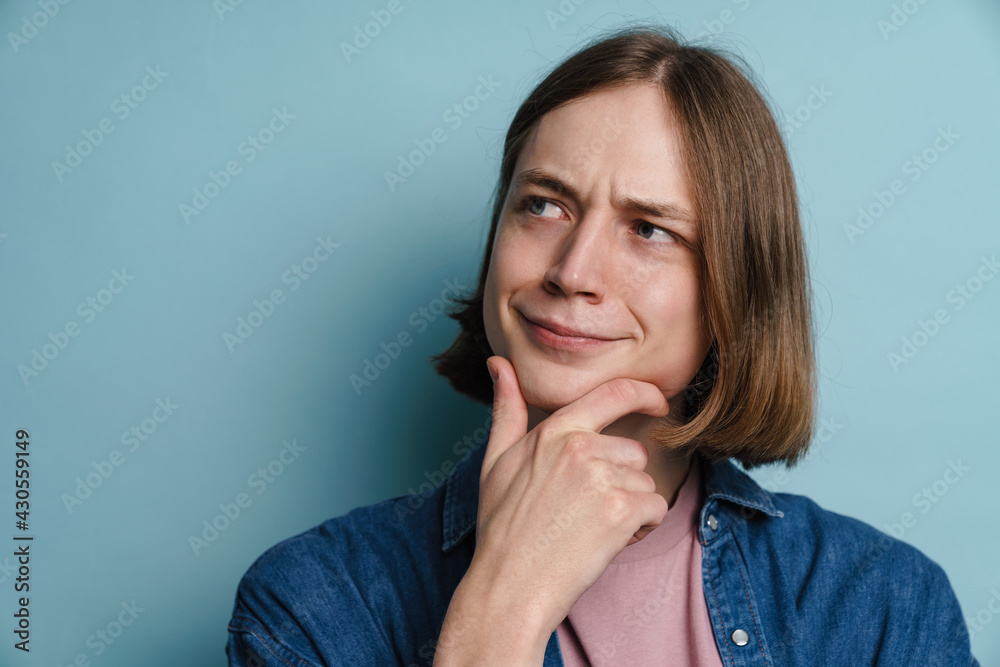 Puzzled european man smiling and looking aside Puzzled european man smiling and looking aside