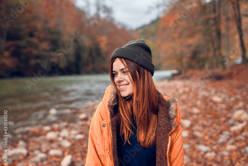 cheerful woman Tourist in a jacket Autumn forest river nature