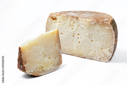a piece of aged pecorino cheese with cheese wheel in white background photo