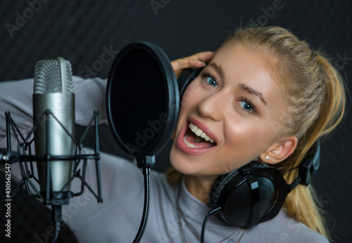 Young woman singing in recording studio