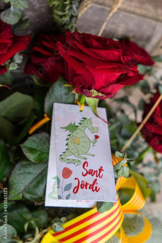 Tarragona, Spain - April 28, 2021: Roses with a dragon card to celebrate Sant Jordi day, the day of the book and the rose in Catalonia. photo