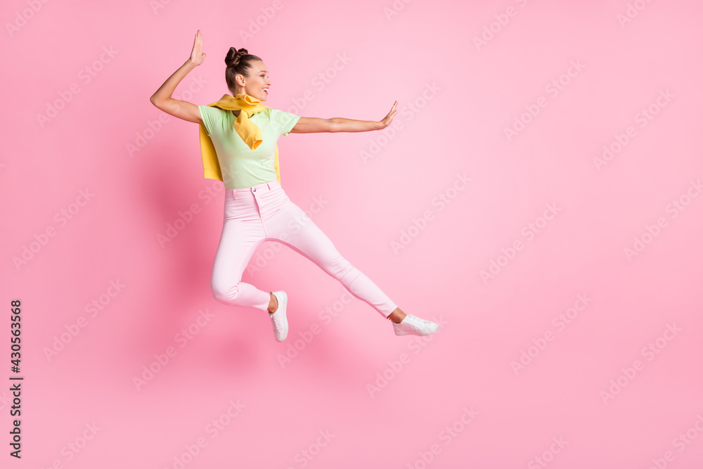 Full body profile side photo of happy active young woman jump up fight wear jumper on shoulders isolated on pink color background