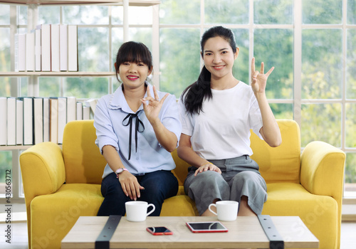 Young and beautiful Asain women sitting and demonstrat and communicate with hand sign, deaf language.