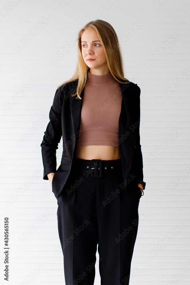 The image portrait. Happy beautiful caucasian woman in a businesswoman suit, black suit In the studio with a white background. The image portrait. Happy beautiful caucasian woman in a businesswoman suit, black suit In the studio with a white background.