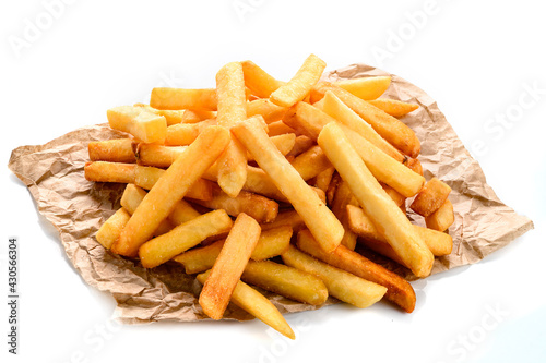 Fast food french fries potatoes with skin served with salt and herbs on baking paper