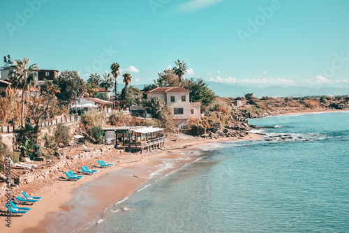 Mediterranean sea beach landscape with turquoise water and blue sun loungers on the sand