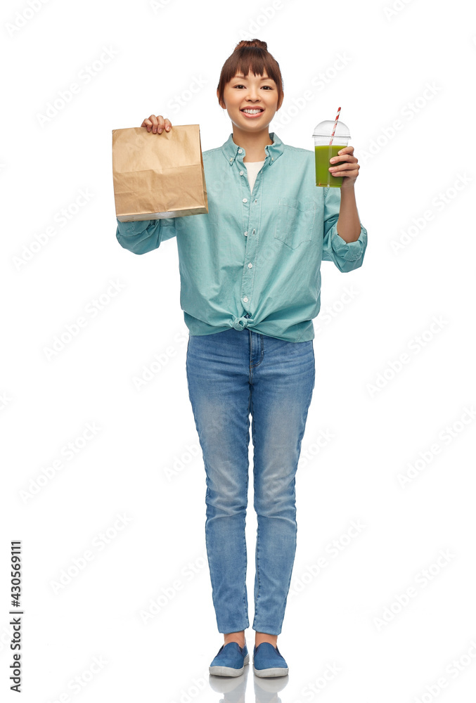 eating and takeaway concept - asian woman drinking green vegetable juice or smoothie from plastic cup with straw and food in paper bag over white background eating and takeaway concept - asian woman drinking green vegetable juice or smoothie from plastic cup with straw and food in paper bag over white background