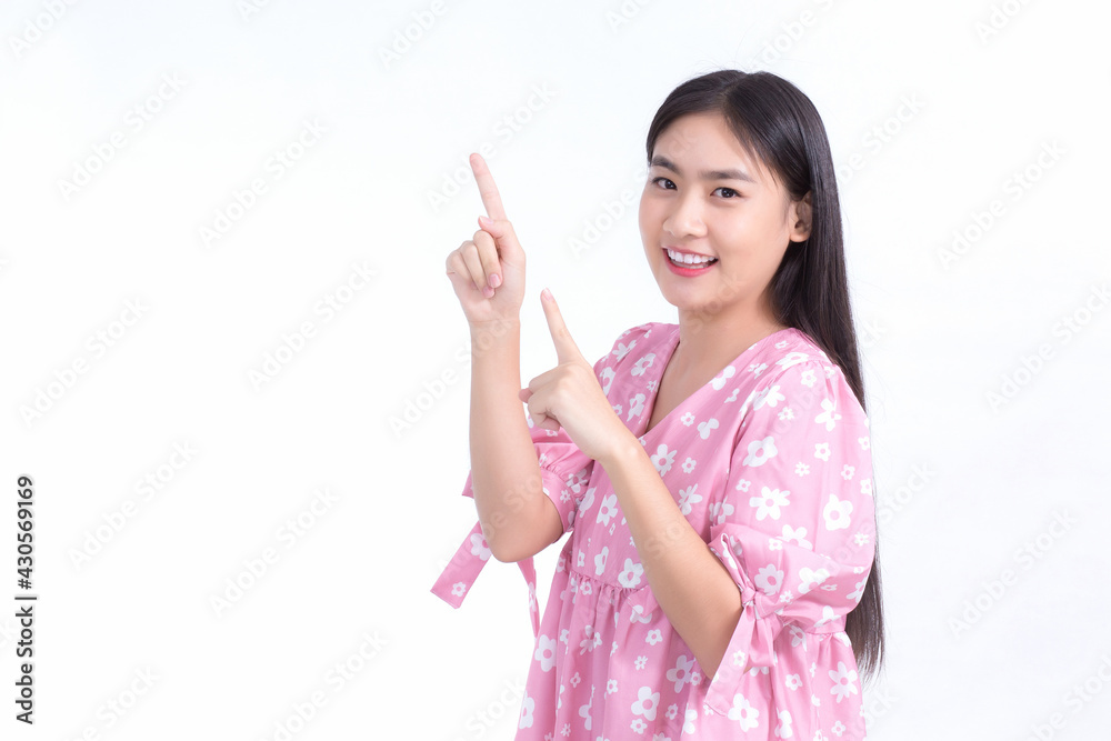 Asian cute girl in pink dress acts exciting and point up to present something on white background. Asian cute girl in pink dress acts exciting and point up to present something on white background.