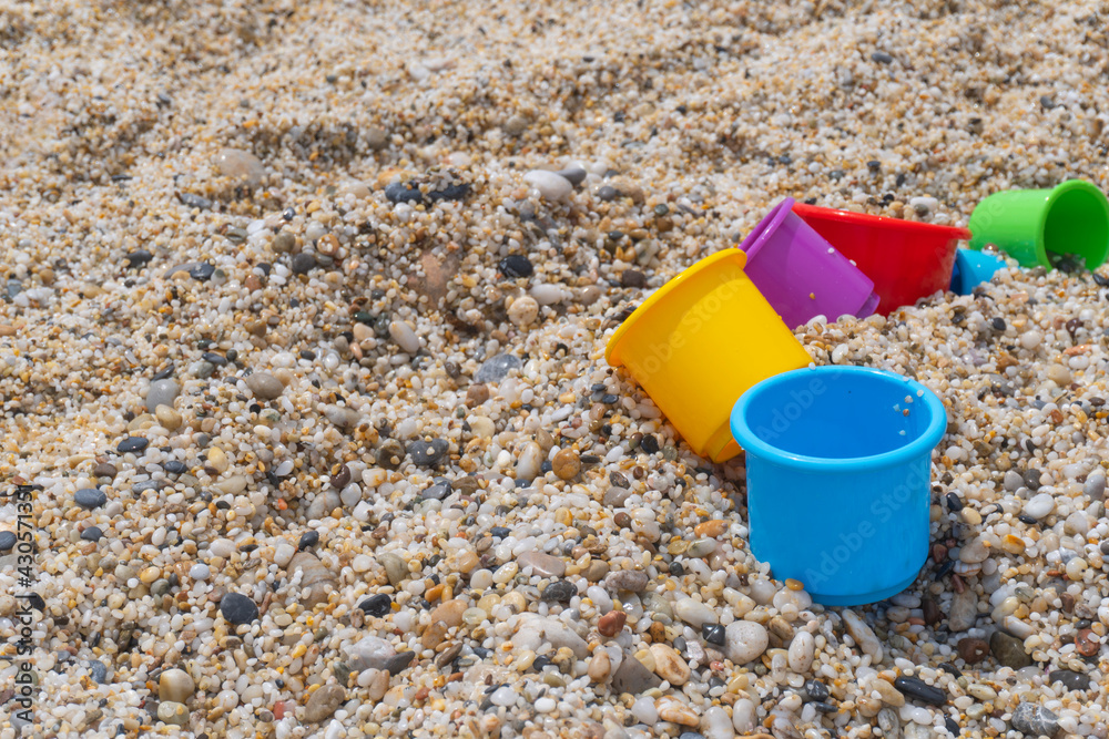 Colorful toys lay on sandy beach, view from the top, copy space, happy childhood having rest at sea resort concept. Colorful toys lay on sandy beach, view from the top, copy space, happy childhood having rest at sea resort concept.