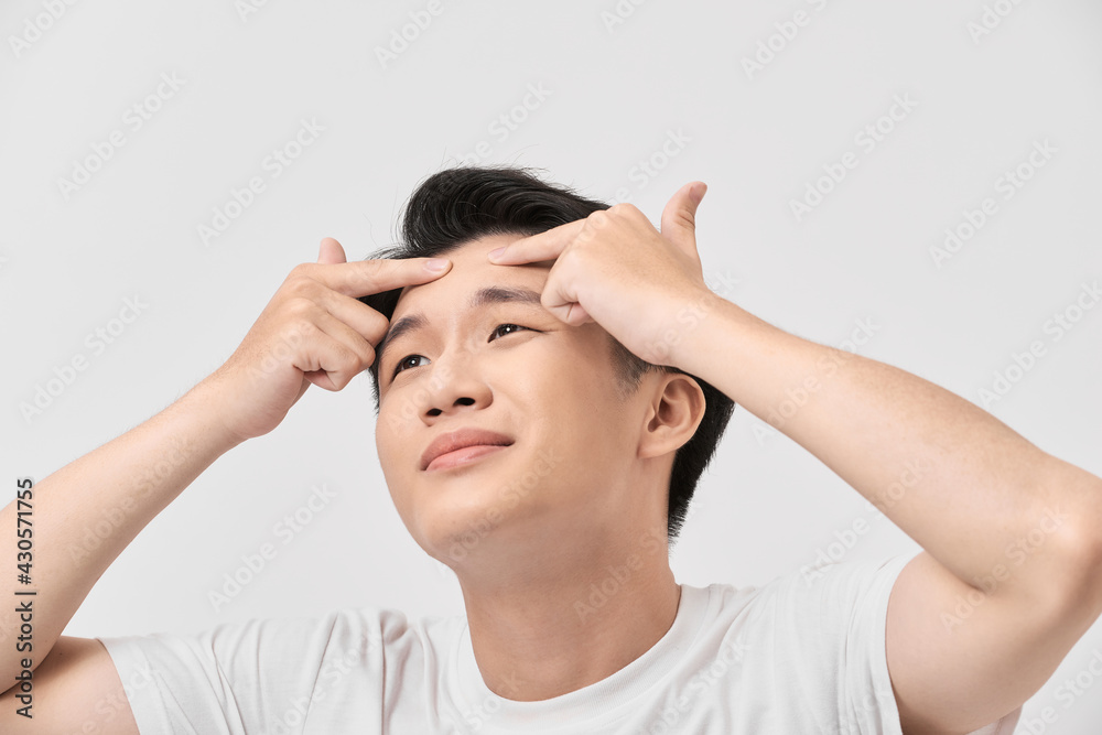 Close up photo of young man looking for acnes on his face Close up photo of young man looking for acnes on his face