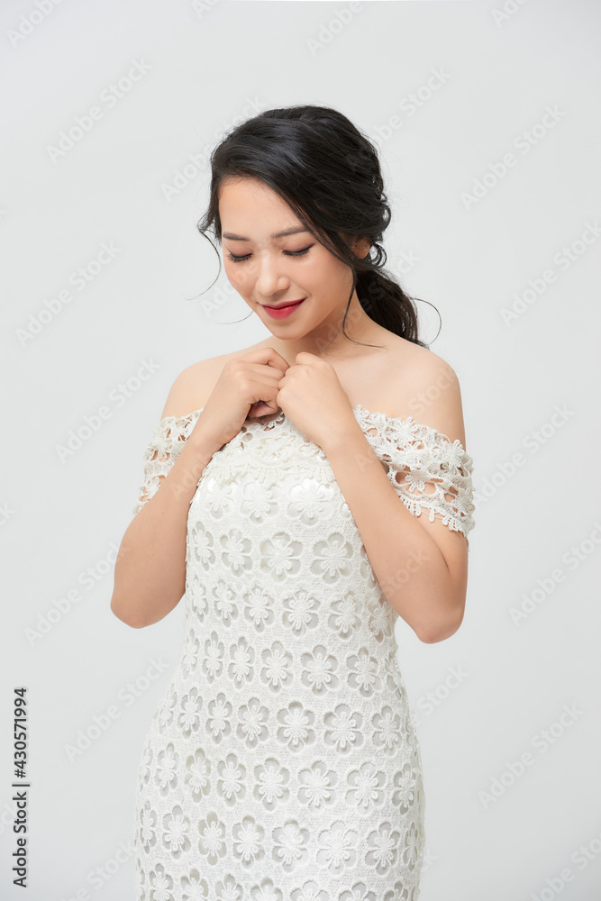 Closeup young romantic lady in wedding festive dress standing indoors on light background, pretty woman posing