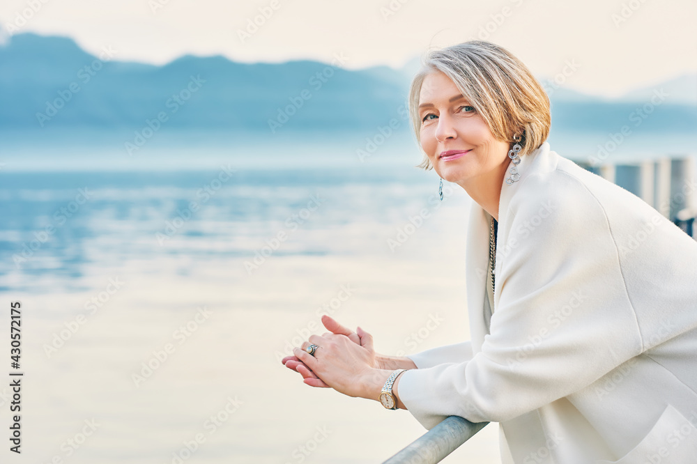 © annanahabed - Beautiful middle age woman admiring amazing view of winter lake and mountains