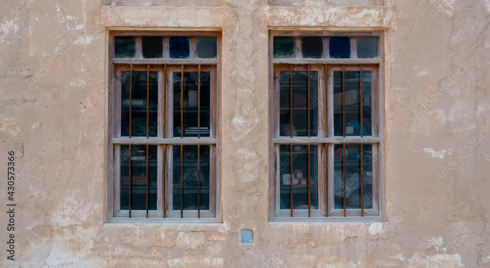 Front view of an Arabic old wall with traditional wooden windows and door in Qatar.