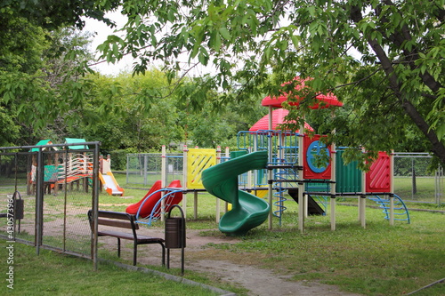 Wallpaper Mural Modern Russian plastic outdoor children play ground on green trees background at summer day, kids vacation on the city yard in Moscow Torontodigital.ca