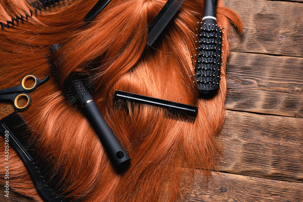 Naklejka premium Hairdressing salon concept background. Redhead women wig and combs on the hairdresser table flat lay background.