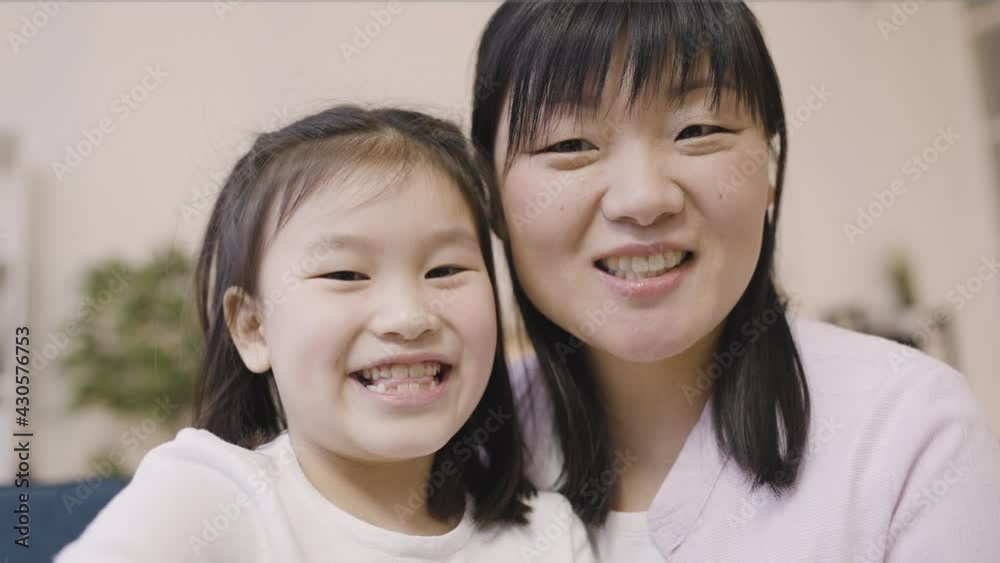 Asian girl and mother talking and smiling, making video call, modern technology Asian girl and mother talking and smiling, making video call, modern technology