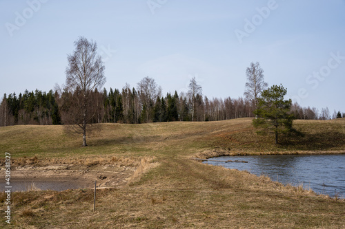 Latvia rural landscape with ponds created for fish farming in the early spring day
