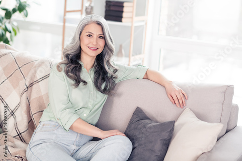 Photo portrait of senior woman sitting on sofa smiling at home