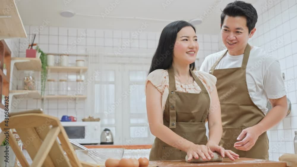 Asian couple learn cooking online, helping each other in the kitchen. Asian couple learn cooking online, helping each other in the kitchen.