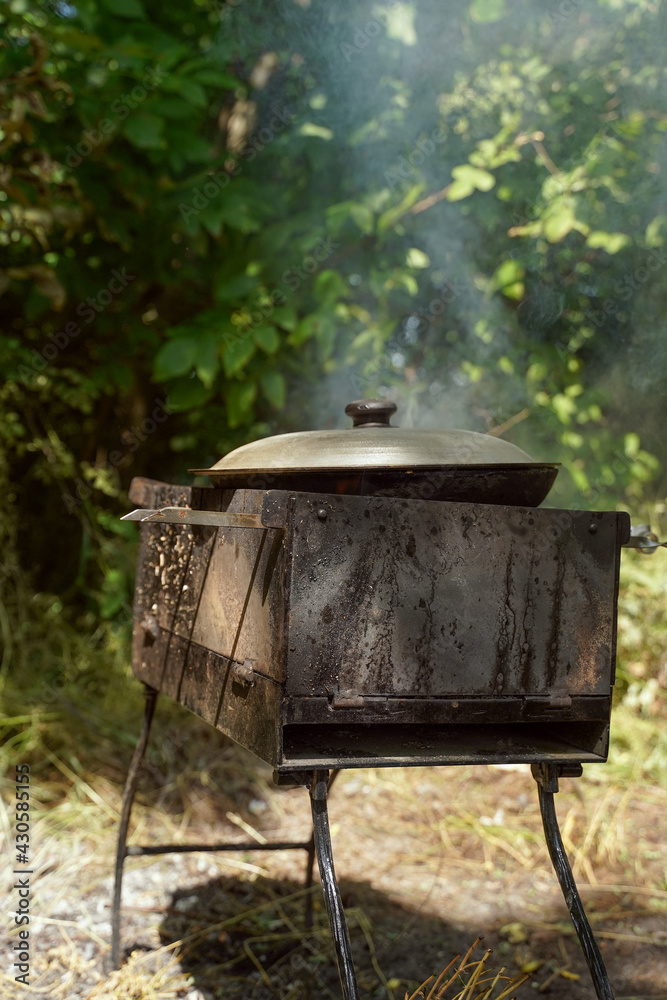 Porridge on the fire. Picnic and food in nature. Lifestyle. Vertical orientation, copy spase, dark moody photo. Porridge on the fire. Picnic and food in nature. Lifestyle. Vertical orientation, copy spase, dark moody photo.